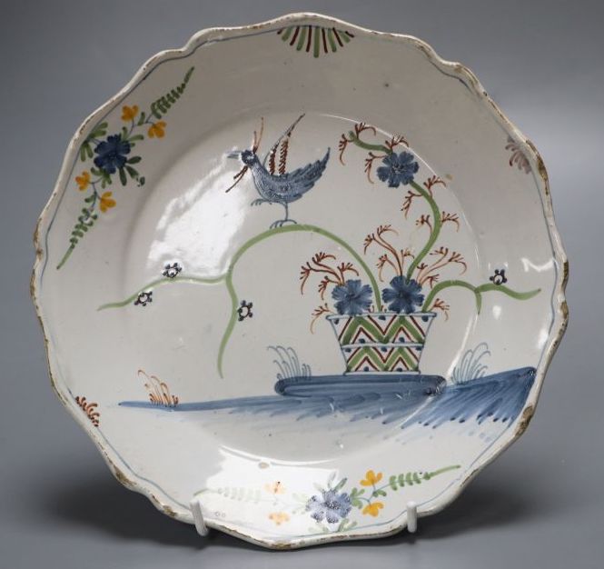 An 18th century faience dish, painted in polychrome enamels, 23cm